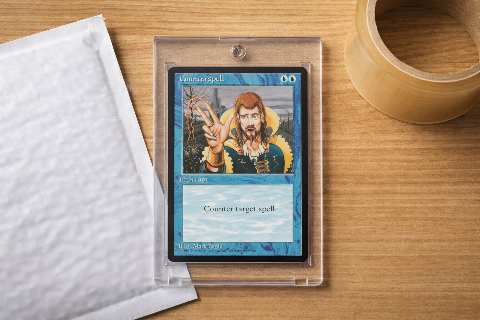 counterspell in a penny sleeve and top loader next to a bubble mailer, ready for shipping
