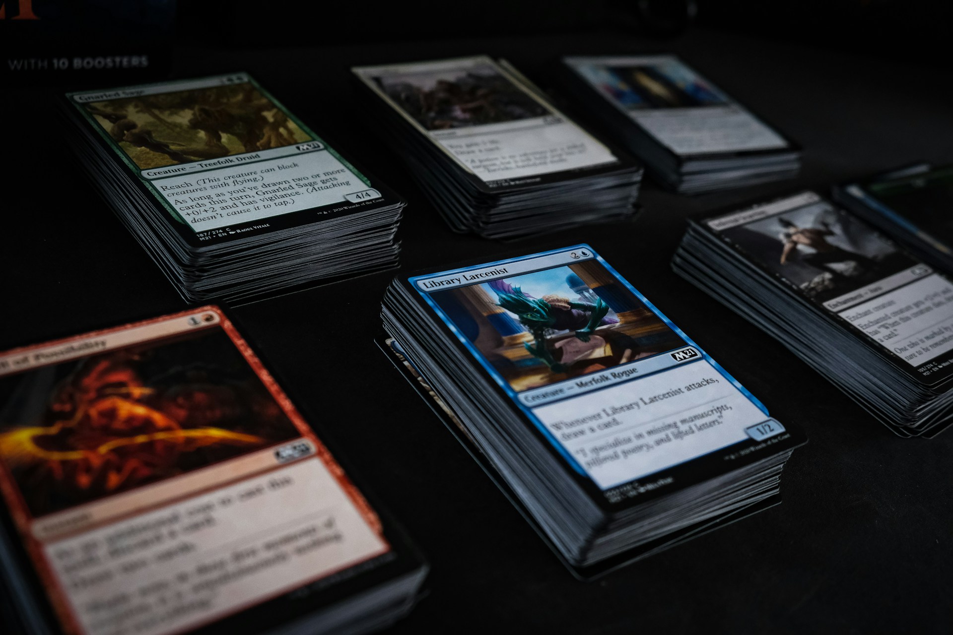 Stacks of sorted Magic: The Gathering cards ready for listing and shipping, showing the kind of bulk inventory that eBay sellers protect with top loaders
